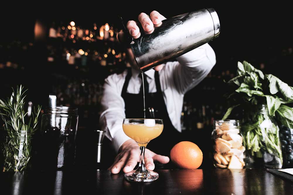 Nachhaltigkeit in der Küche - Ausbildung und Karriere - Bartender pouring cocktail