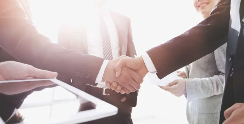 Rechtsformwahl im Zuge einer Betriebsübergabe im Familienverband - Ausbildung und Karriere - employees look at the handshake business partners