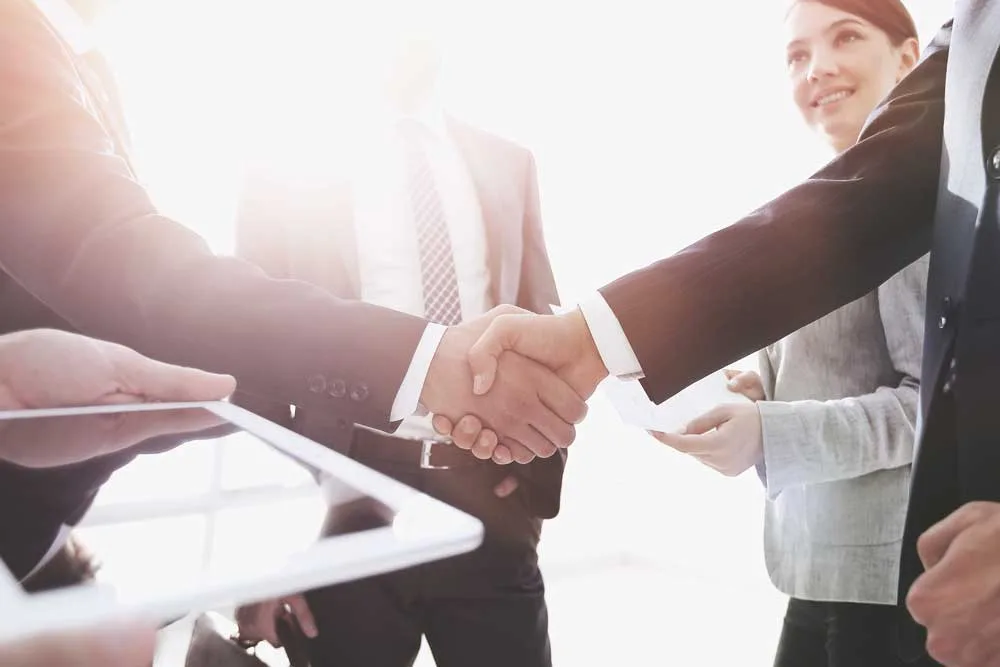 SHOP-GASTRONOMIEBETRIEB FÜR NEUES, HOCHFREQUENTIERTES OBJEKT GESUCHT! - Immobilien - employees look at the handshake business partners jpg